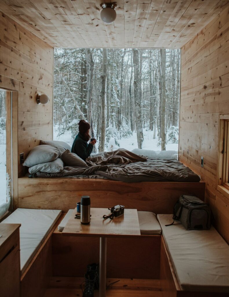 Travelers review a rental floor plan and amenities beside luggage in a bright cabin living room.