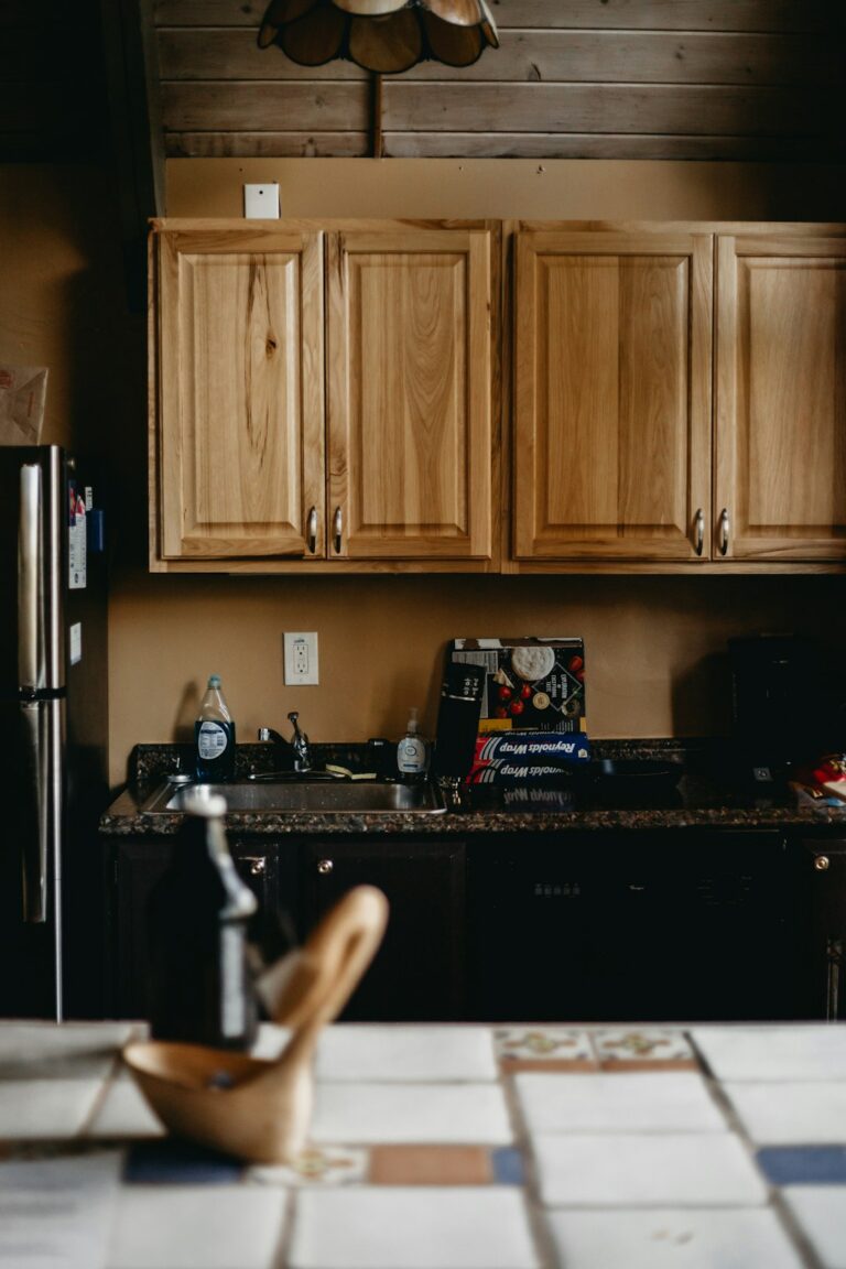Friends compare vacation rental costs at a kitchen table with receipts, groceries, and a calculator.